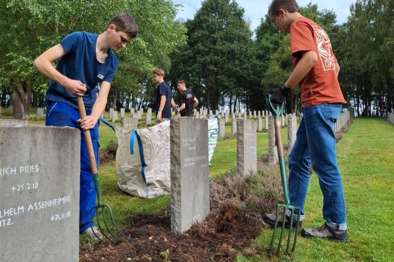 Teenagers tending the graves August 2025