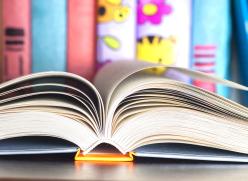 Image of an open book in front of a childs books