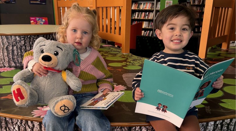 Children in library with helpful bear