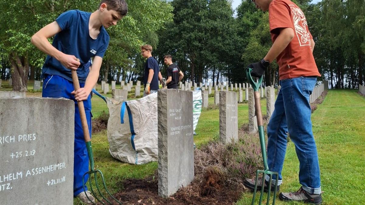 Teenagers tending the graves August 2025