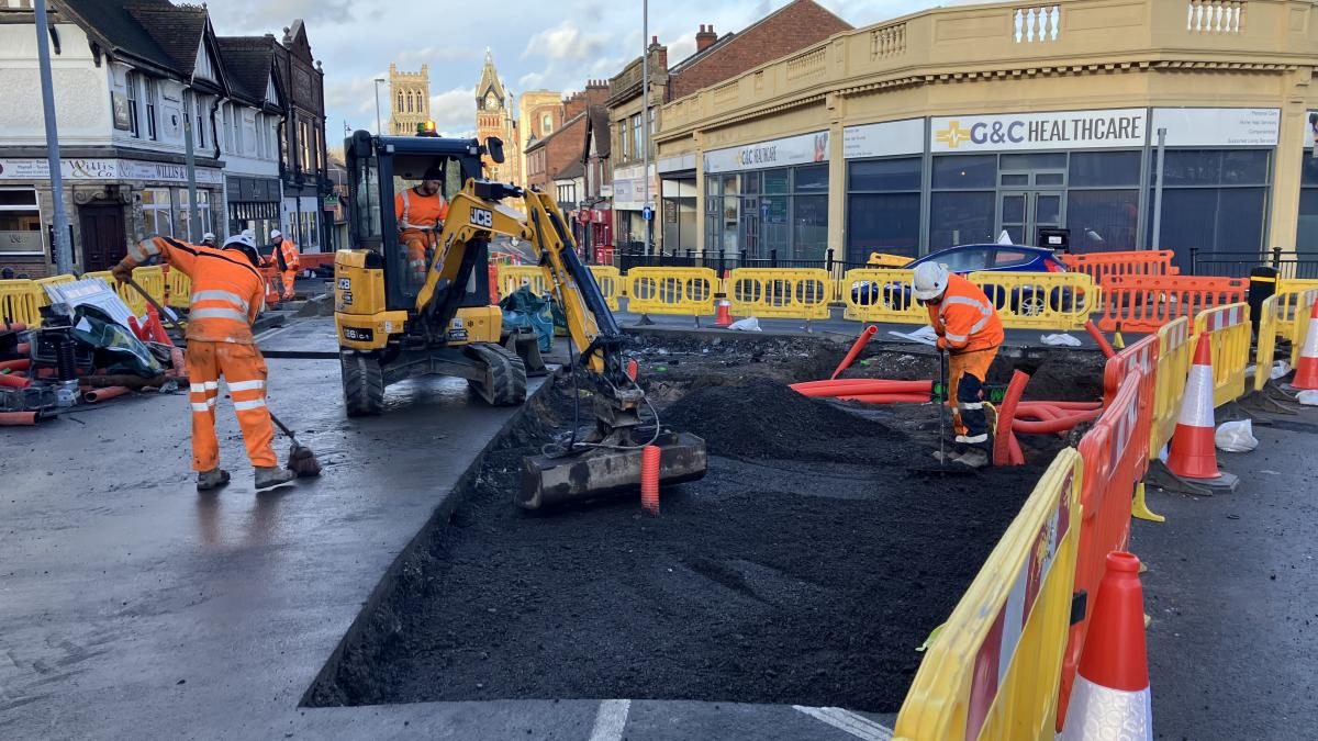 Highways crews in orange high vis uniform working on a road.