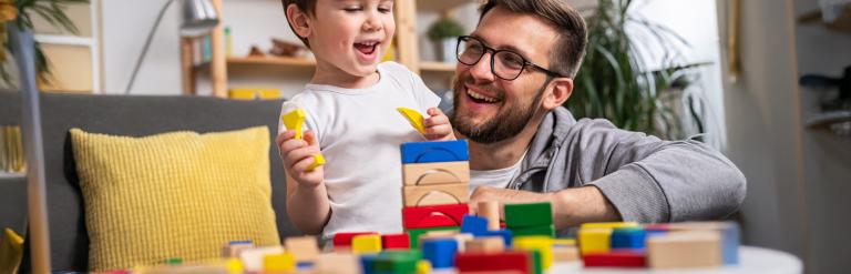 An adult and child playing with blocks
